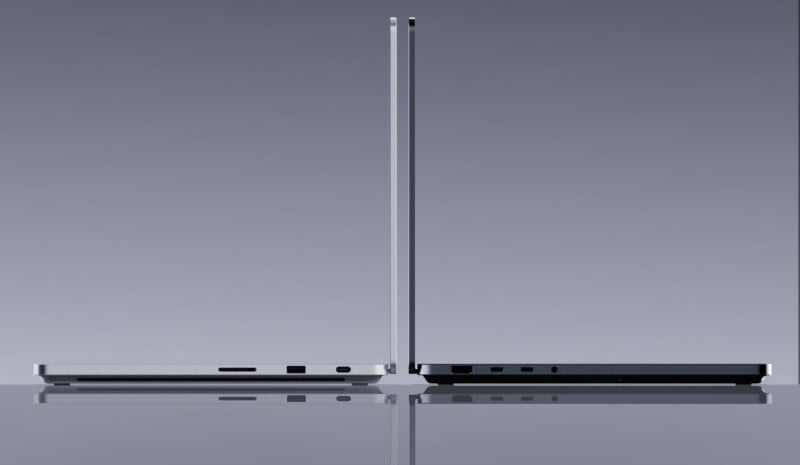 Two slim laptops are positioned back-to-back, both open at a 90-degree angle, showing their thin profiles and side ports against a neutral gradient background.