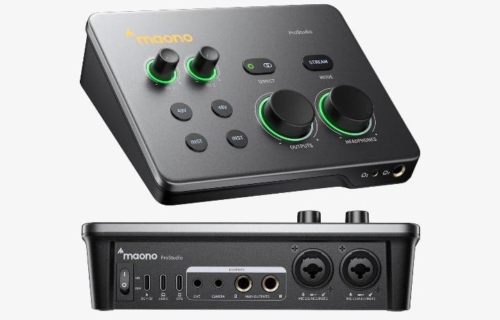 A black Maono audio interface with various knobs, buttons, and input/output ports. The top panel has illuminated green rings around controls, and the front panel displays multiple audio input and output connections.