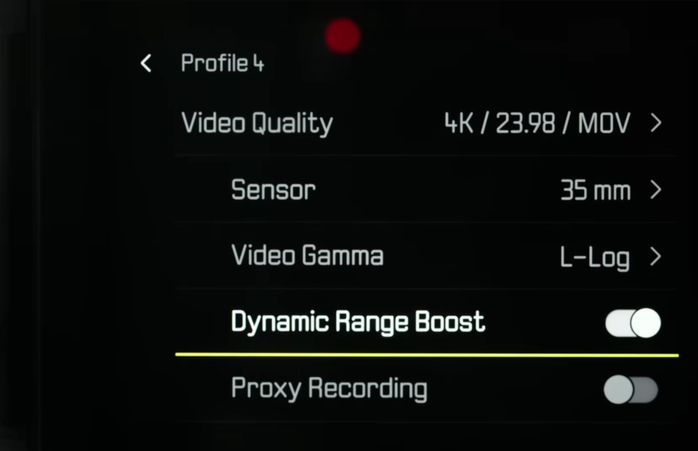 Camera settings menu showing Profile 4 with 4K/23.98 MOV video quality, 35 mm sensor, L-Log video gamma, Dynamic Range Boost toggled off, and Proxy Recording option listed below.