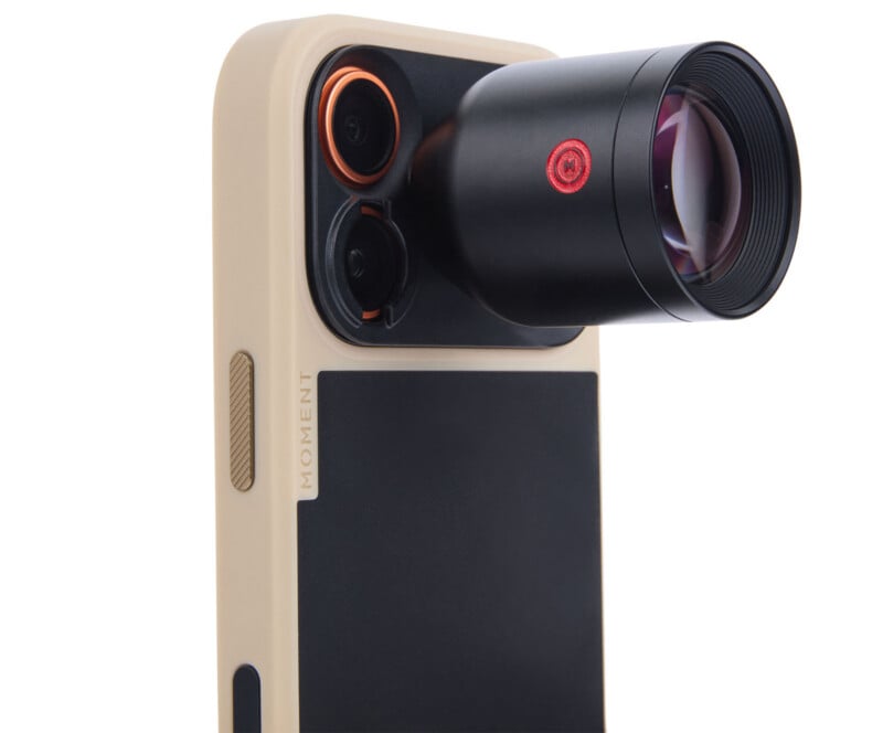 A close-up of a beige smartphone case with a large detachable black camera lens attached to the corner, featuring the brand name "Moment" on the side.