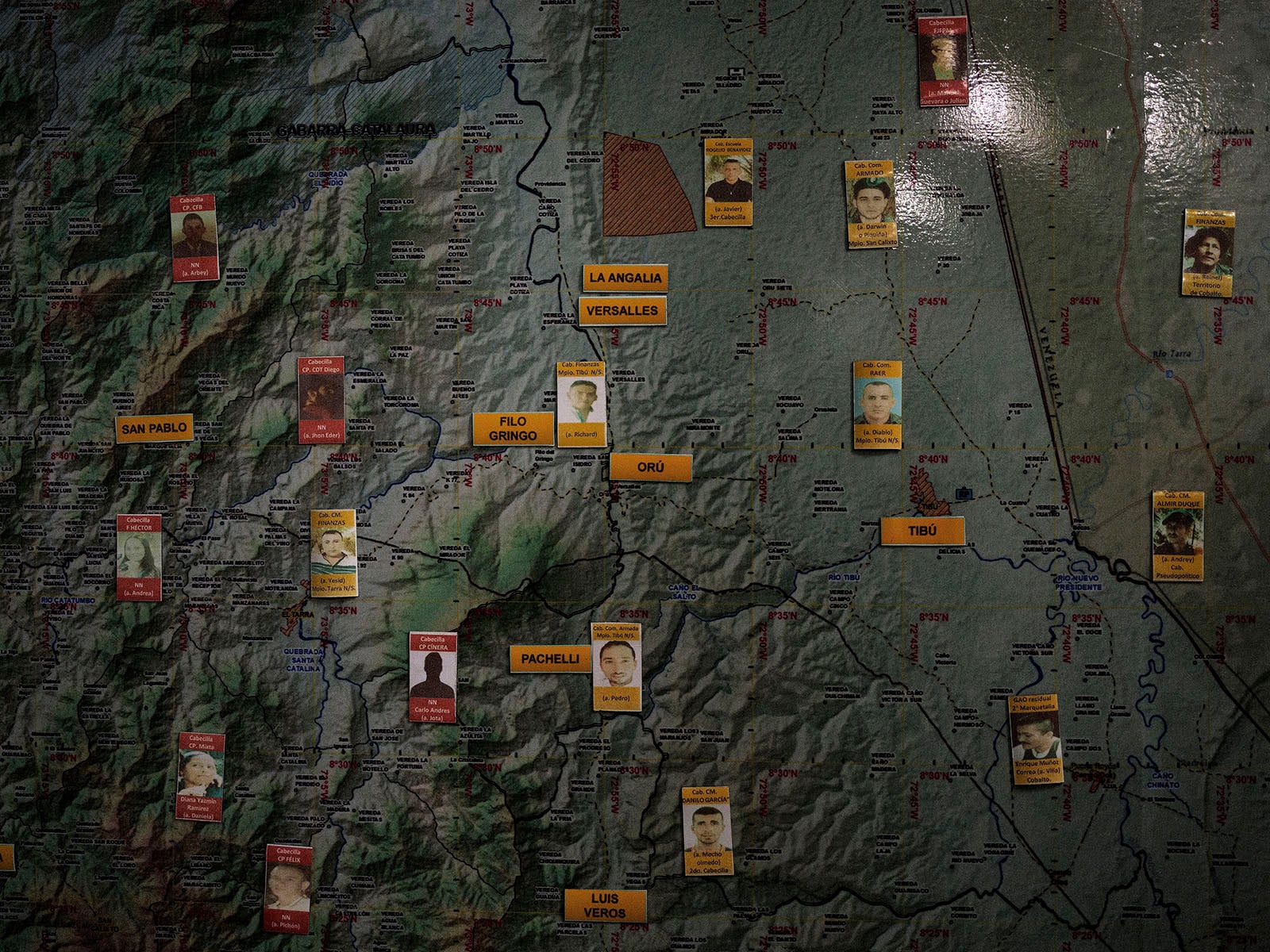 A map with various labeled locations and passport-style photos of people attached, connected to different places. The map features areas such as San Pablo, La Angalia, Veracruz, and Pichili.