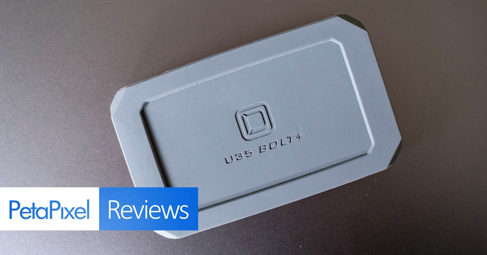 A gray rectangular storage device labeled "U35 BOLT+" is shown on a dark surface. The bottom left corner features a "PetaPixel Reviews" graphic.