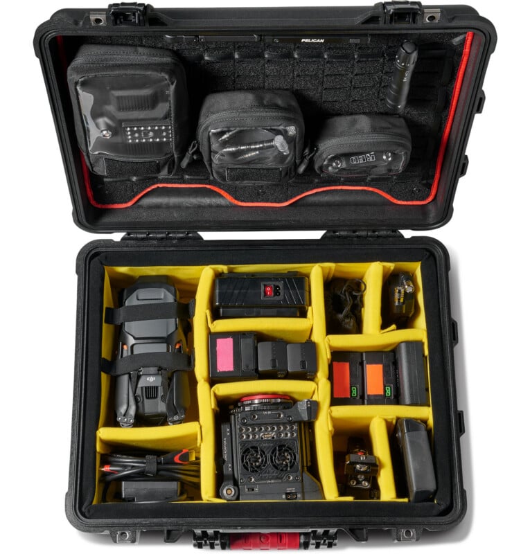 An open black hard case with yellow dividers holding a drone, batteries, remote controller, cables, and camera accessories. The lid has organized pouches and gear, all neatly arranged for travel or storage.
