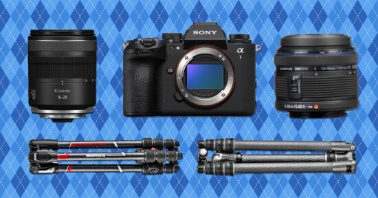 A Sony Alpha camera is centered between a Canon lens and an Olympus lens. Below are two folded carbon fiber tripods, all on a blue patterned background.