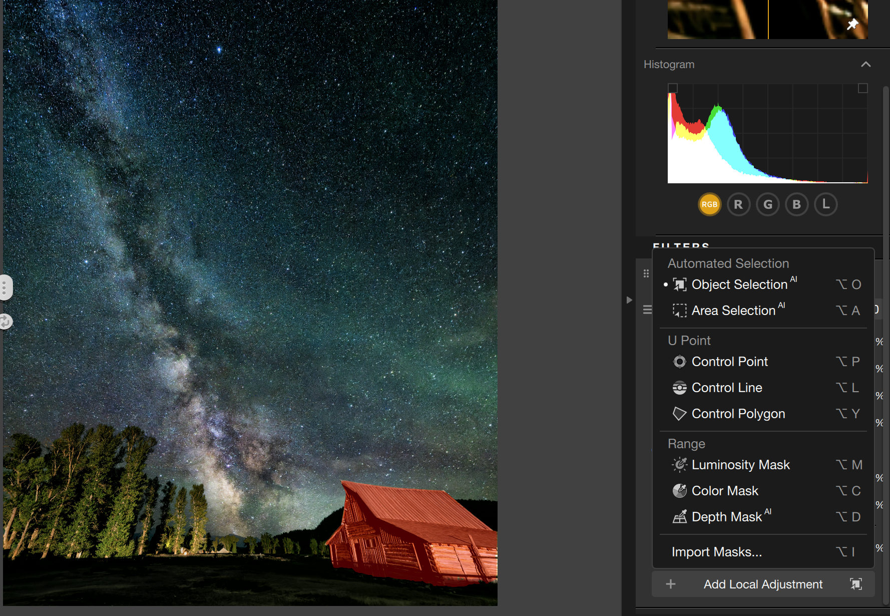 A star-filled night sky with the Milky Way stretches above trees and a red cabin; photo editing software interface with adjustment panels is visible on the right side of the screen.