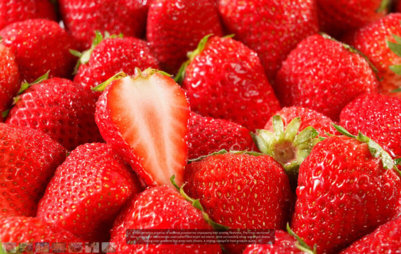 A close-up of fresh, ripe strawberries with vibrant red color. One strawberry is sliced in half, revealing its juicy, white and red interior among whole strawberries. The fruit appears glossy and appetizing.