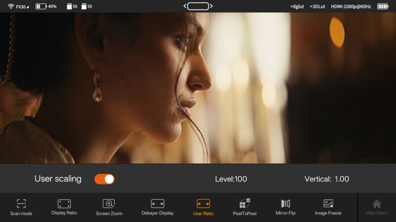 A close-up profile of a woman with soft lighting and blurred background, displayed on a monitor screen with display settings and controls visible at the bottom.