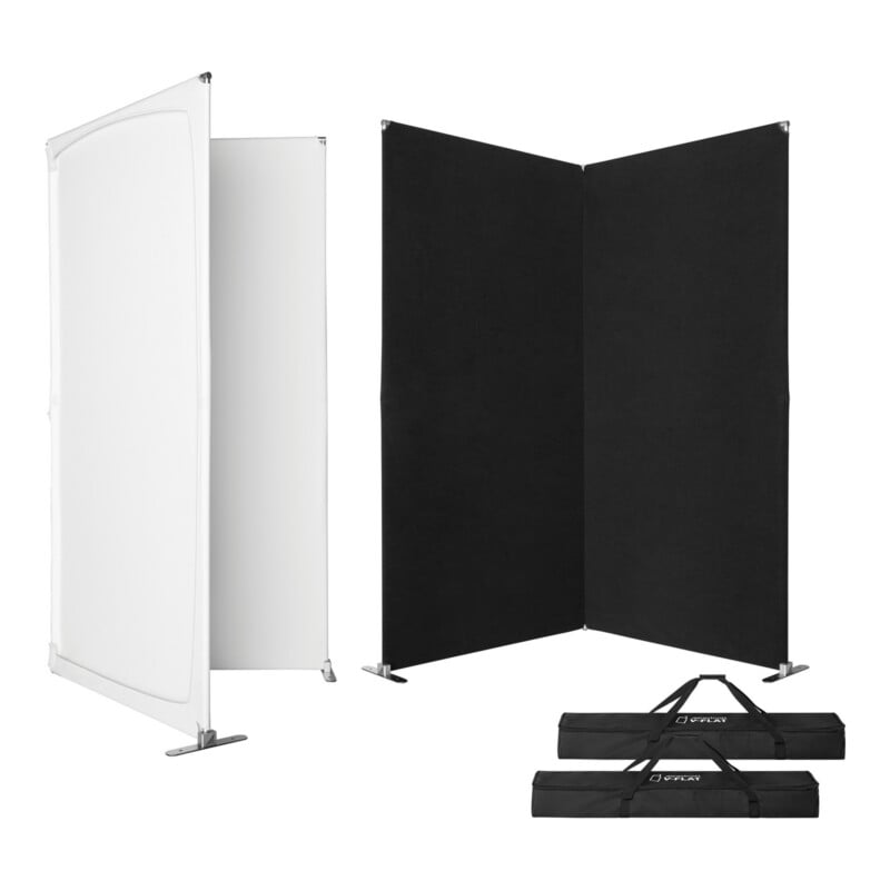 Two portable display panels are shown: one with a white screen and one with a black surface, both supported by metal frames. Two black carrying bags lie on the floor in front of the panels.