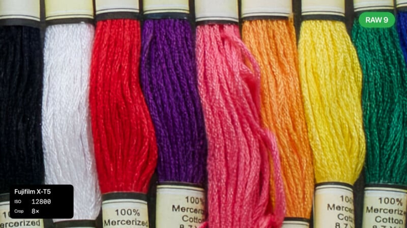 Eight skeins of embroidery floss in white, red, purple, pink, orange, yellow, and green are lined up vertically. Camera settings and a "RAW 9" label appear overlaid on the image.