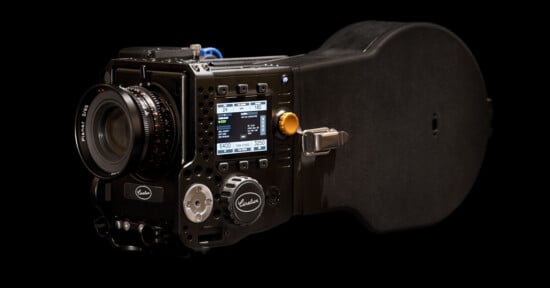 A high-end digital cinema camera with a large lens, control dials, and a display screen showing settings, set against a black background.
