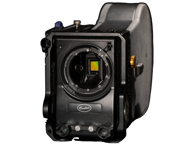 Close-up of a professional underwater camera housing with the front lens port open, revealing the camera sensor and internal components. The housing is black with buttons, dials, and a visible logo.