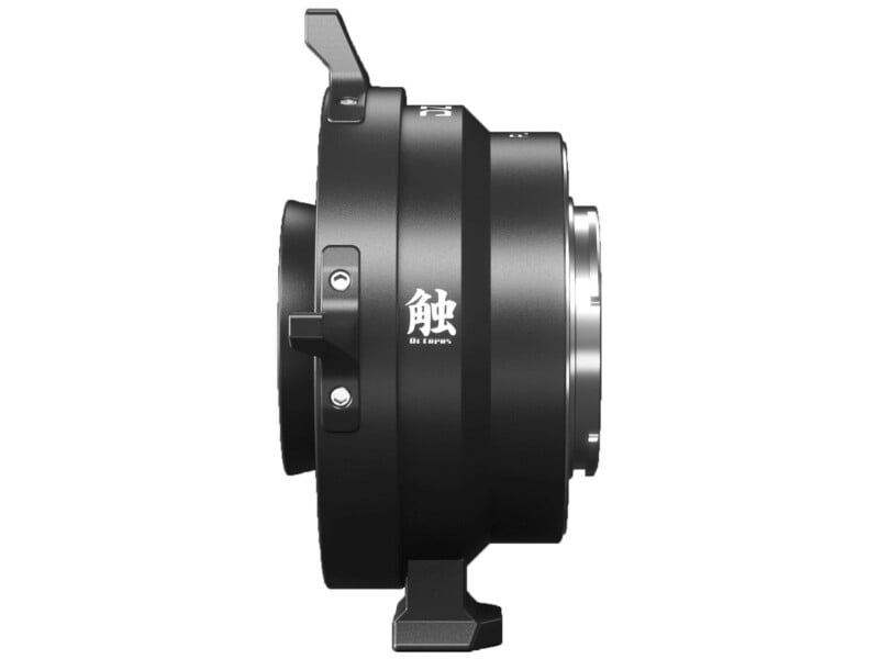 Side view of a black camera lens adapter with silver mounts and white Japanese text on the side. The adapter has two protruding tabs on the top and bottom and a compact, cylindrical design.