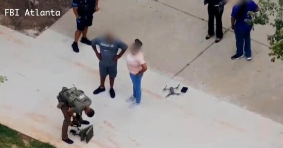 A law enforcement officer kneels near a drone and gear on a sidewalk, while two people with blurred faces stand nearby. Three others, also with blurred faces, are standing close. The text "FBI Atlanta" is on the image.