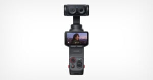A handheld Insta360 camera with a dual-lens system on top, featuring a touchscreen display showing a woman outdoors, and various control buttons on the handle. The background is plain white.