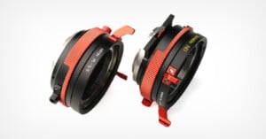 Two black and red camera lens adapters with metal levers and engraved markings are positioned side by side on a white background. One adapter has "ND Variable" written in yellow text.