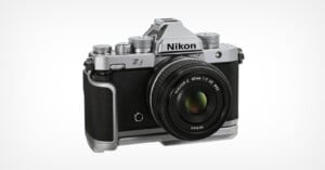 A Nikon Z f mirrorless digital camera with a retro silver and black design, shown with a NIKKOR Z 40mm f/2 SE lens attached, against a plain white background.