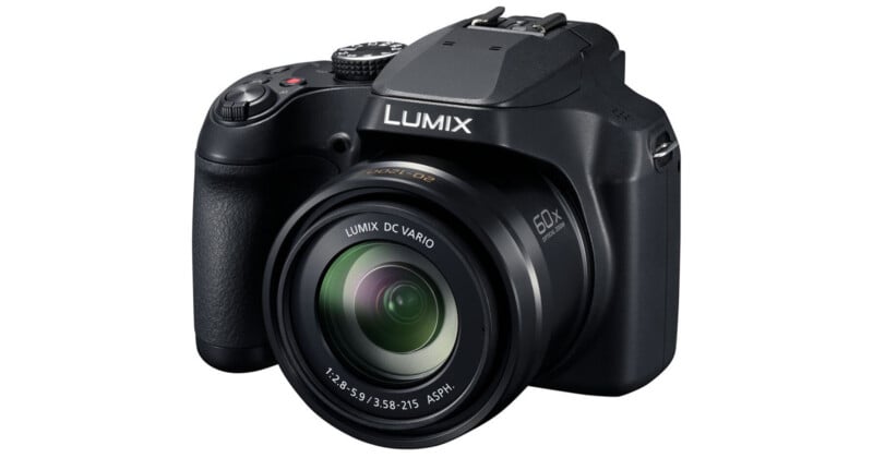 A black Panasonic Lumix digital camera with a zoom lens, angled to show the front and side controls, labeled "LUMIX" on the top above the lens.