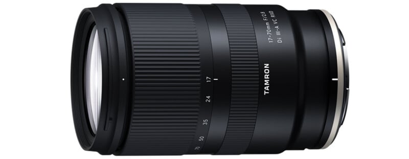 A Tamron 17-70mm f/2.8 Di III-A VC RXD zoom camera lens, shown from the side, featuring a black body with white markings and a textured zoom ring.