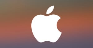 A white Apple logo with a bite taken out of the right side is centered on a blurred gradient background of warm and cool tones.