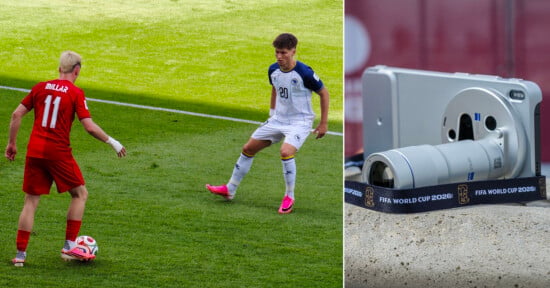A soccer player in a red uniform faces an opponent in a white uniform during a match. Next to them, a close-up shows a camera labeled "FIFA World Cup 2026" set up on the sidelines.