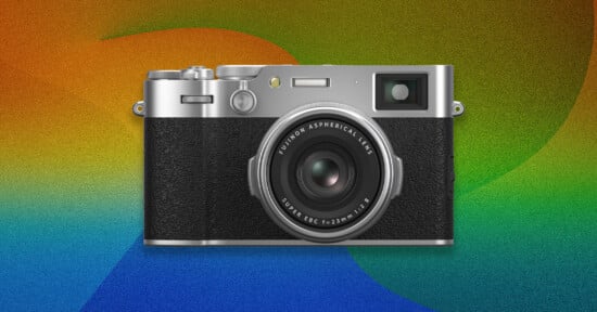 A silver and black Fujifilm camera is centered against a colorful, textured background featuring gradients of orange, green, and blue.