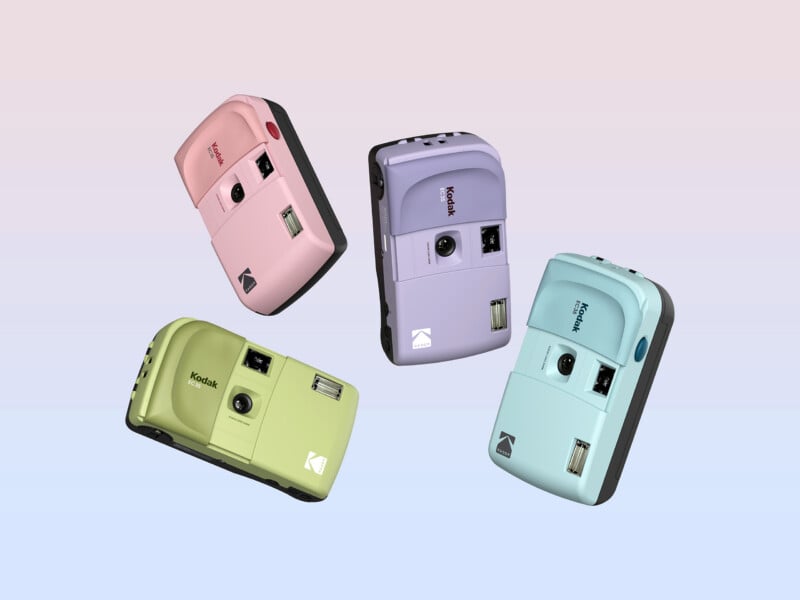 Four Kodak cameras in pastel pink, purple, green, and blue are floating against a gradient pastel background. Each camera has a retro style, with a prominent flash and lens on the front.