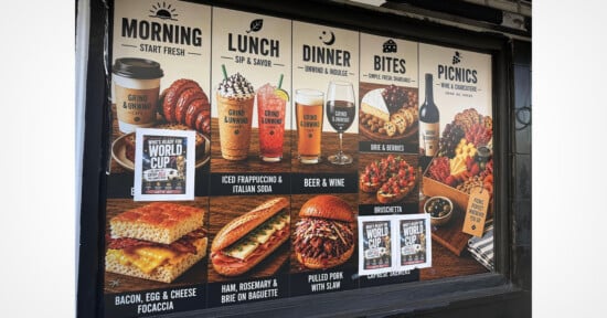 Menu board showing offerings for morning, lunch, dinner, bites, and picnics with images of coffee, sandwiches, soda, beer, wine, and cheese. Text highlights breakfast sandwiches, iced drinks, and pulled pork with slaw.