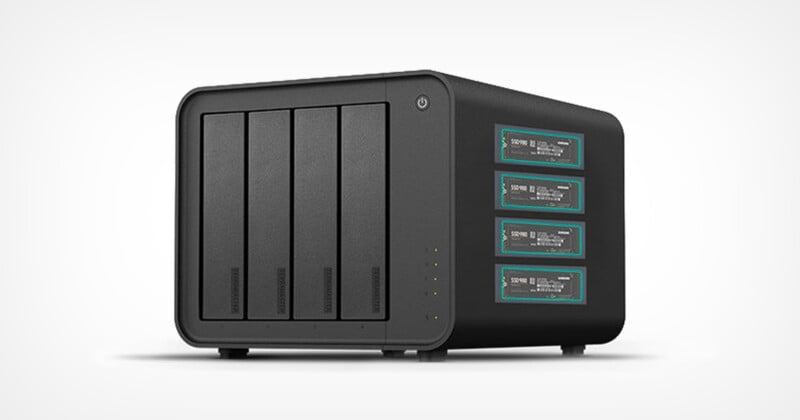 A black network attached storage (NAS) device with four vertical drive bays on the left and four panels with digital displays on the right, set against a plain white background.