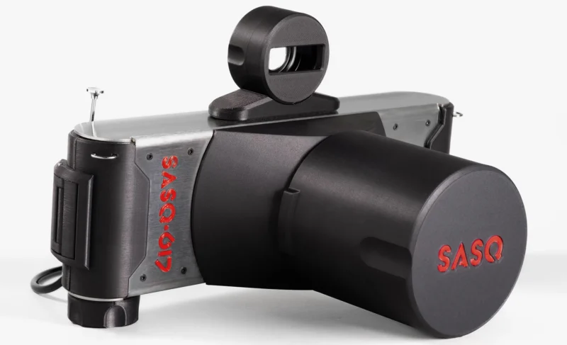 A SASQ-617 panoramic film camera with a black lens cap and a top-mounted viewfinder, set against a white background.