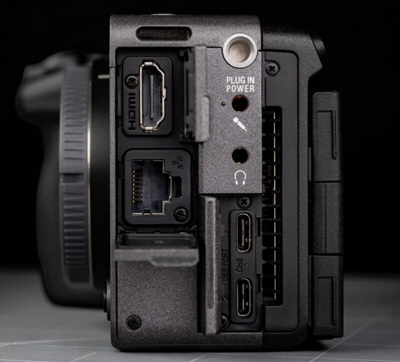  HDMI, LAN, USB-C, headphone and microphone jacks, and a power input. The covers for some ports are open, revealing the connectors.