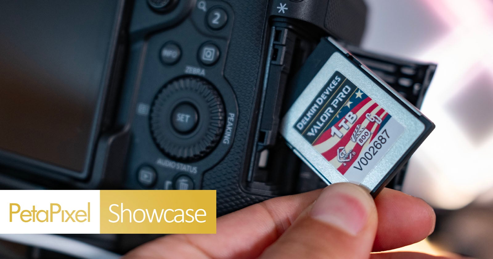 A hand inserts a 1TB memory card labeled "Delkin Devices" into a digital camera. The camera's LCD screen and control buttons are visible. "PetaPixel Showcase" text is displayed in the corner of the image.