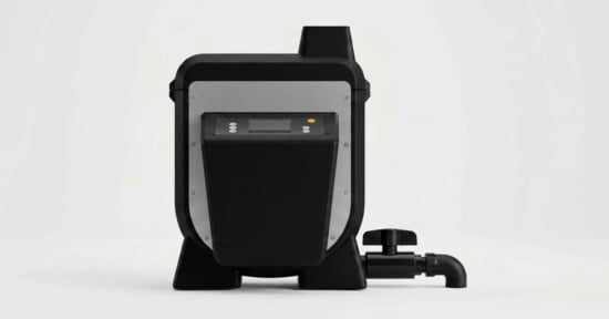 A black and silver industrial device with a digital display, control buttons, and a black pipe fitting with a valve on the right side, set against a white background.