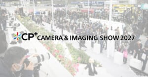 Crowds walk through a busy camera expo with photographers using large lenses. Text reads: "CP+ Camera & Imaging Show 2027." Bright, modern indoor setting.