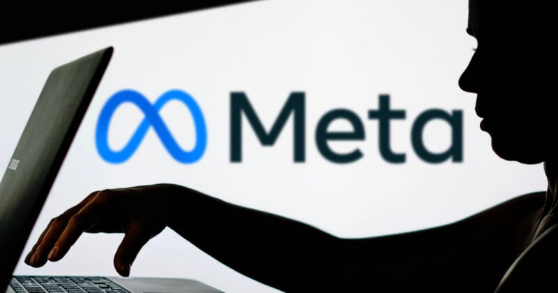 A silhouette of a person using a laptop in front of a screen displaying the Meta logo and name on a white background.