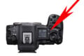Top view of a Canon camera with a large red arrow pointing to the mode dial and power switch area on the right side of the camera body.