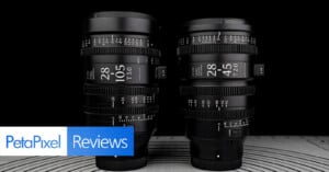 Two black camera lenses with detailed markings are displayed upright side by side on a patterned surface. The left lens is labeled 28-105mm T3.0 and the right 28-45mm T2.0. "PetaPixel Reviews" text is at the bottom left.