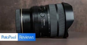 A Tamron 20-40mm camera lens with a lens hood sits on a brown surface. Text at the bottom left reads “PetaPixel Reviews.”.