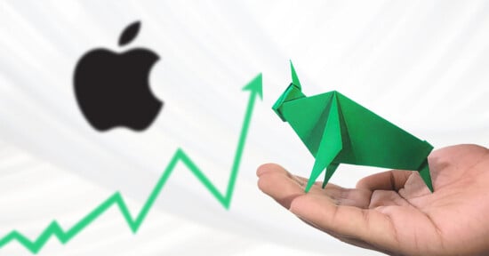 A hand holds a green origami bull in front of the Apple logo, with a green upward stock chart line in the background, symbolizing a bullish trend for Apple.