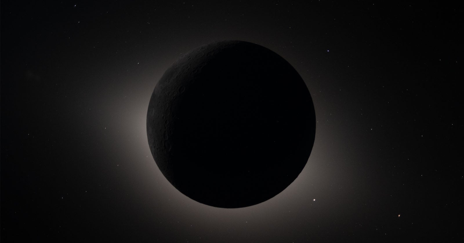 A dark celestial body, likely a moon or planet, is silhouetted against a faint, glowing halo of light with a starry background in space. The object's surface features are barely visible.