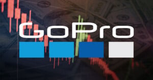 The GoPro logo is superimposed over a background of US hundred-dollar bills and a downward-trending stock market candlestick chart, suggesting a decline in the company's financial performance.