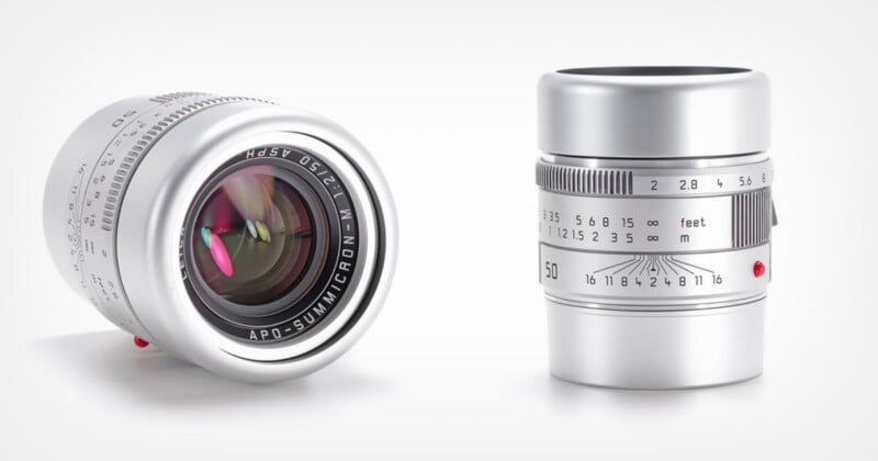 Two silver camera lenses are shown: one standing upright displaying its focus and aperture markings, the other lying on its side, showing its glass element and lens branding "APO-SUMMICRON-M 1:2/50.