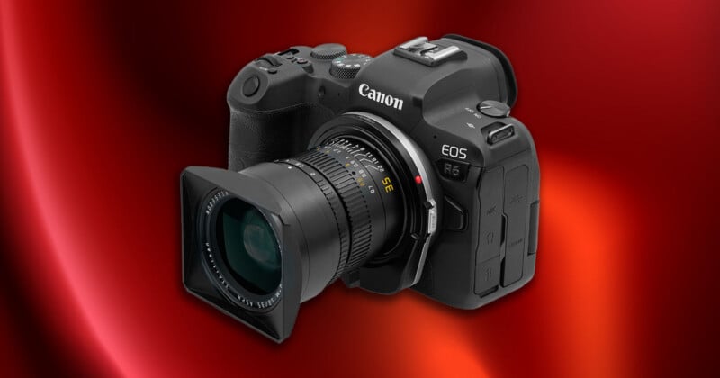 A black Canon EOS R6 camera with a wide-angle lens is shown on a shiny red gradient background.