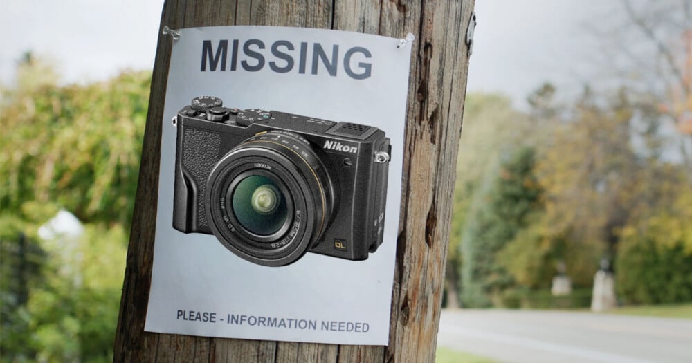 A "missing" poster on a wooden pole features a photo of a Nikon camera, requesting information. The background shows a road and green trees.