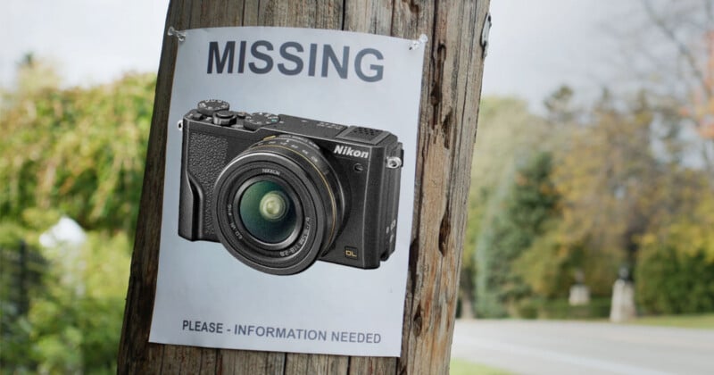 A "missing" poster on a wooden pole features a photo of a Nikon camera, requesting information. The background shows a road and green trees.