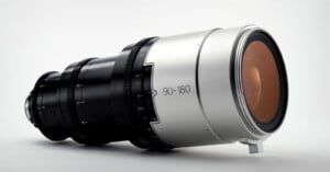 A professional camera lens with a metallic silver finish and black focus rings, marked "90-180," displayed against a plain white background.