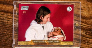 A trading card in a clear case shows a man in white holding a baby in pink, both against a red background. The card reads “LIONEL MESSI & LAMINE YAMAL” at the bottom. Top left text: “STADIUM Chrome 1/1.”.