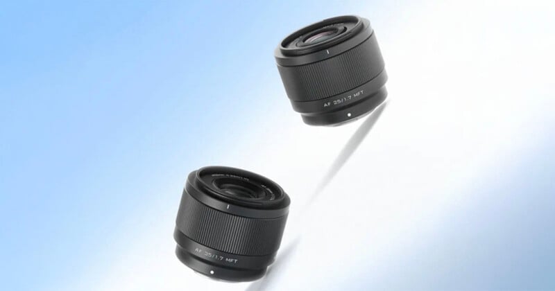 Two black camera lenses are displayed against a gradient blue and white background, with one lens casting a faint shadow beneath it.