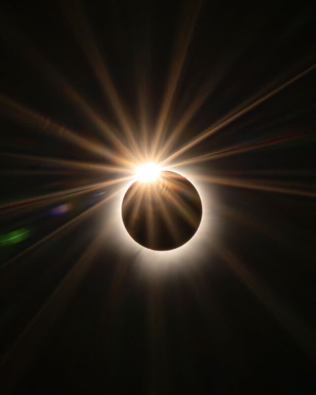 A total solar eclipse showing the moon silhouetted against the sun, creating a bright diamond ring effect with radiating light.