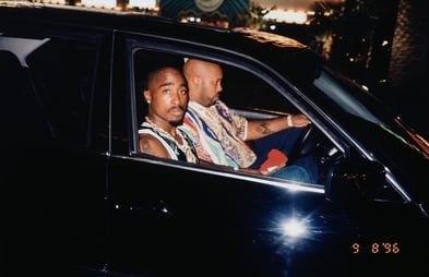 Tupac Shakur sits in the passenger seat of a black car next to Suge Knight, who is driving, on September 7, 1996.