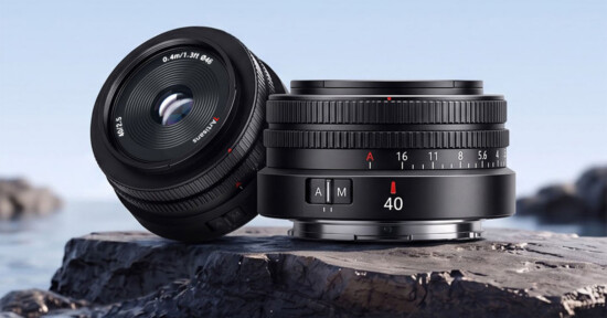 Two 7Artisans 40mm f/2.5 camera lenses rest on a dark, textured rock against a blurred blue background.